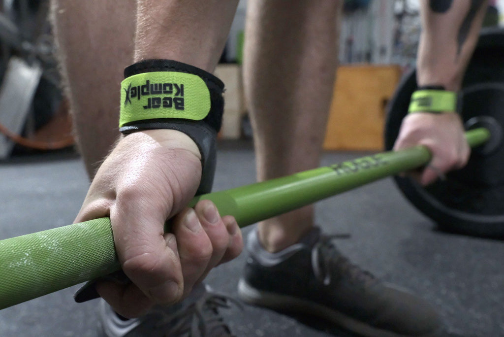 Man gripping a barbell wearing Bear Komplex Diamond 3-Hole Gymnastic Grips with Green Velcro Strap | FreeAthlete