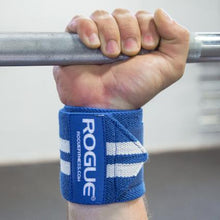 Load image into Gallery viewer, Man gripping bar to showcase Rogue Wrist Wraps - White Series in Blue with White Stripes